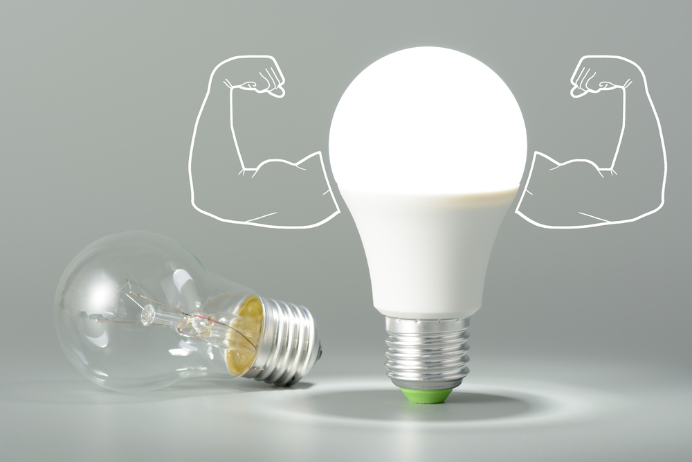 Energy-efficient lighting evolution from traditional incandescent bulb to modern LED bulb with muscle arm illustrations symbolizing strength.